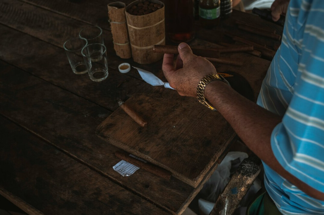 Hands holding a mate gourd over documents on a table
